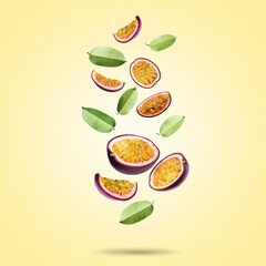 Delicious cut passion fruits and green leaves falling on pale yellow gradient background