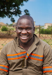 village rural ,portrait of african smiling man, in front of a house with thatched roof , countryside living,