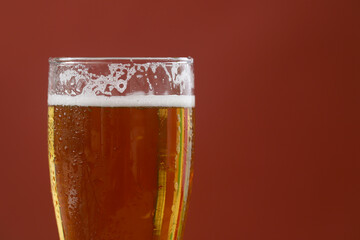 Cold beer with foam in a glass, ready to drink.