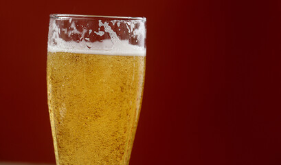Cold beer with foam in a glass, ready to drink.
