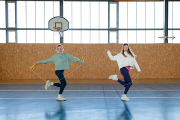 Girls Having fun training synchronized movements in gymnasium 