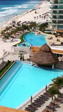 Travel destinations. Aerial view on sea beach with resort with swimming pool. Vertical footage