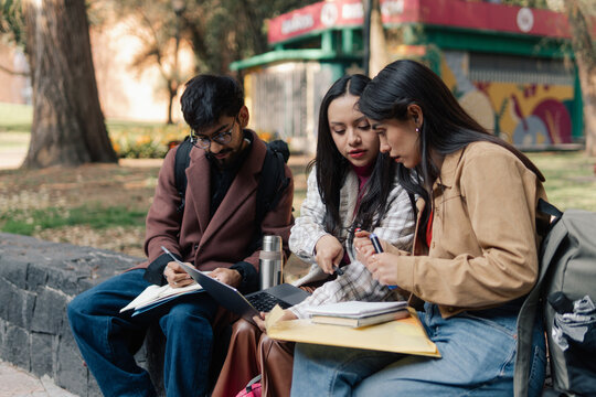 Three students are seen studying together 