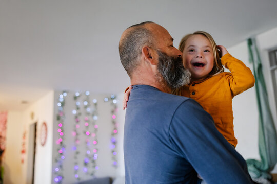 Joyful Moment of Dad and Child Bonding in a Warmly Lit Room