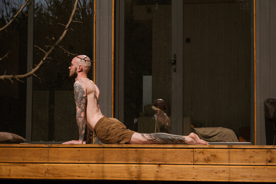 Practicing yoga outdoors in a serene environment with tattoos
