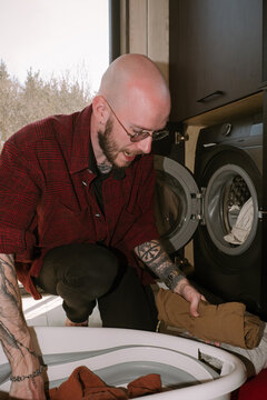 Man doing laundry at home with modern appliances and casual style