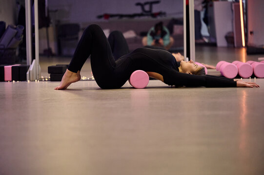 Deep stretch with foam roller in yoga studio