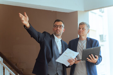 A two man businessman Reviewing Documents and Digital Tablet in Modern Office