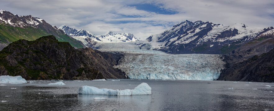 A beautiful tidewater glacier meets the sea as mountains of the Chugach Range rise above.  Captured on a glacier cruise from Whittier Alaska.