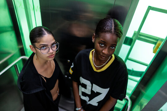 High angle portrait of young women in illuminated elevator