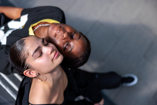 Serene diverse female friends with head tilted back and eyes closed