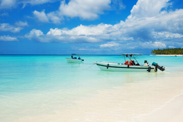 Boats on a tropical beach against the backdrop of the blue Caribbean Sea.