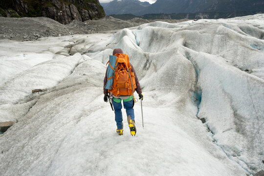 Adventurer Trekking Glacial Landscape with  technical winter Gear