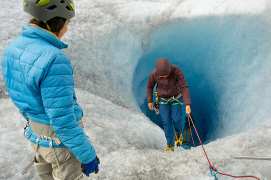 two explorers in a glacier blue ice cave