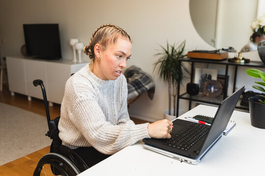 Woman in Wheelchair Working on Laptop at Home