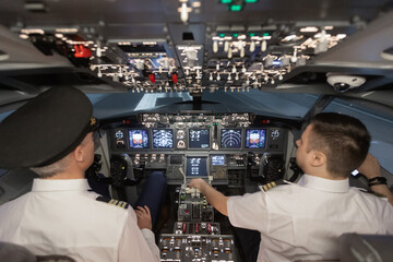Airline pilots operating aircraft from cockpit at night