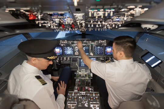 Airline pilots operating airplane cockpit flight controls 