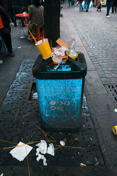 Trash bin full to the top of garbage in the streets of MIlan
