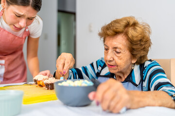 Grandmother teaching granddaughter secret baking recipes in the kitchen