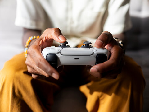 Person Holding a Gaming Controller During Video Game Session