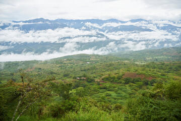 Obraz premium Colombian Andean landscape, mountains, covered with green vegetation wrapped in layers of clouds.