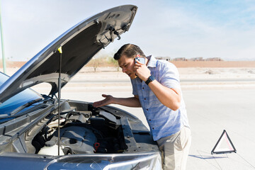 Stressed driver calling for roadside assistance after car breakdown on highway