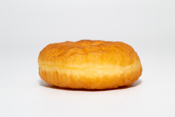 golden-brown donut with a fluffy texture sits on a white background