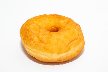 A classic, golden-brown donut with a slight rise, perfectly centered on a clean white surface.