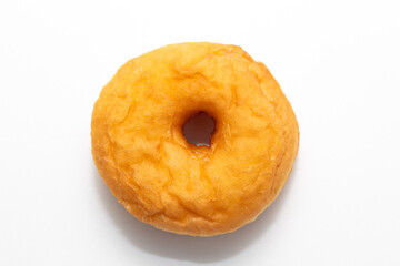 golden-fried donut, perfectly round with a hole in the center, presented against a clean white backdrop.