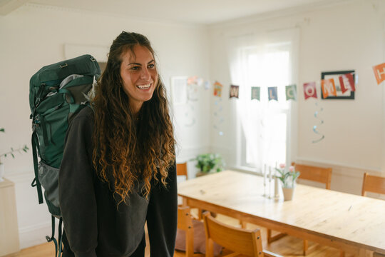 young woman with backpack coming home 