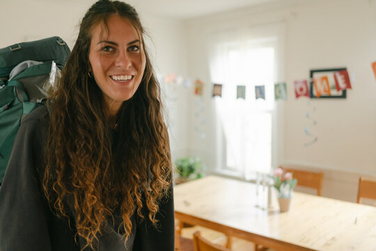 young woman with backpack coming home 