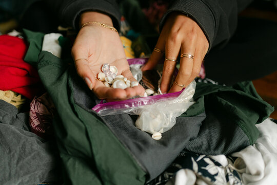young woman unpacking her bag, looking at shells she brought back