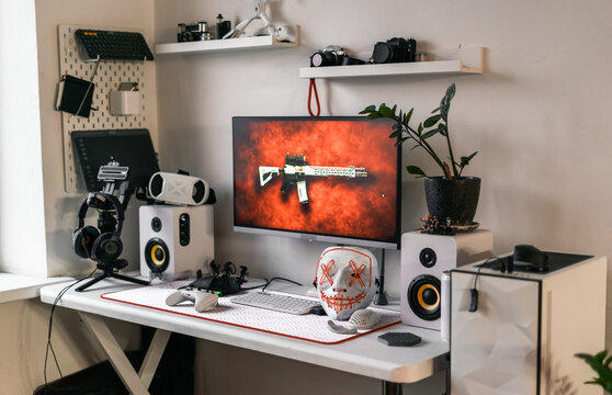 Modern gaming desk setup with stylish computer, gaming accessories, VR headset, controllers, mechanical keyboard, and cyberpunk mask Perfect atmosphere for esports streaming, and creative digital work