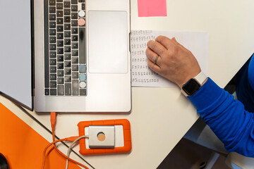 Hand writing at laptop workstation