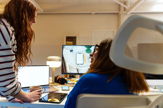 Coworkers sharing a moment at desk


