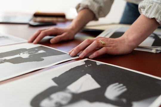 Hands Reviewing Black-and-White Portraits