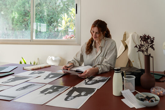 Woman Reviewing Black-and-White Portraits - Powered by Adobe
