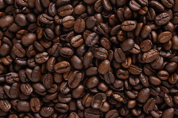 Roasted coffee beans background. Top view of dark brown coffee beans. Close up image.