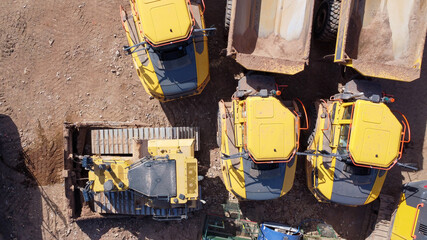 Aerial top down view of quarrying vehicles parked by a field
