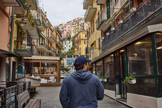 Fototapeta A young man walking through old Italian village
