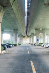 Concrete structure and asphalt road space under the overpass in the city