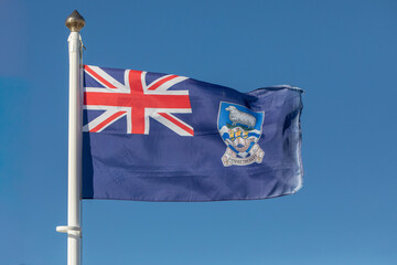 The flag of the Falkland Islands flutters in the breeze in the capital, Stanley. The motto reads,...