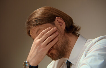 Stressed businessman covering face with hand