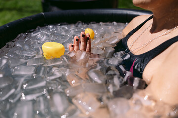 Athlete woman meditating during ice bath therapy for muscle recovery