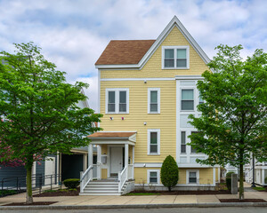 Traditional and modern architectural elements in a charming yellow house on a spring day in...