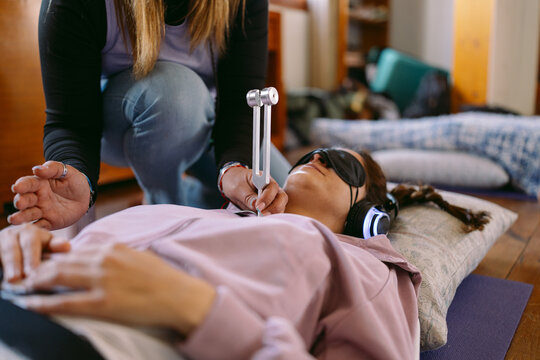 Therapist using tuning fork during sound healing therapy session