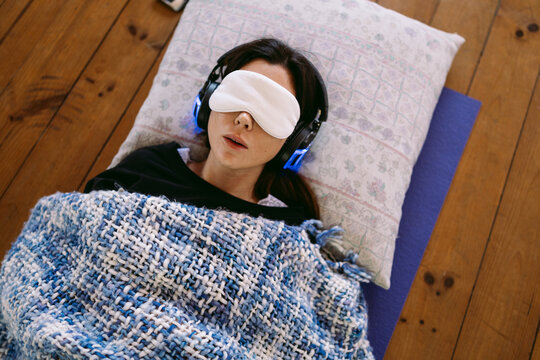 Young woman relaxing with eye mask and headphones,