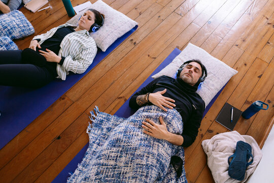 People relaxing and breathing during guided meditation session
