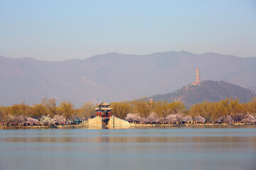 Beijing Summer Palace West Causeway spring scenery featuring ancient architecture and peach blossoms