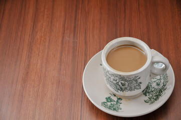 a cup of hot coffee on a wooden table
